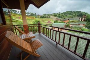 a balcony with a bench and a view of a river at ดอยหมอกดอกไม้รีสอร์ท DoiMok DokMai Resort in Mae Salong
