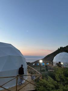 a man standing in front of two domes at Shatyly Lake ViewGlamping in Bokonbayevo