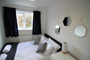 a bedroom with a white bed with a window at St James House - Charming 3 bed, 2 bathrooms, driveway parking, close to town centre in Newcastle upon Tyne