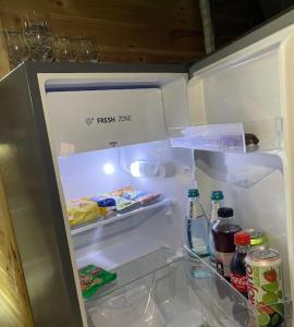 an open refrigerator with food and drinks in it at Shatyly Lake ViewGlamping in Bokonbayevo