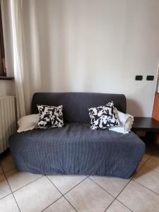 eine blaue Couch mit Kissen darauf in einem Zimmer in der Unterkunft Appartamento San Siro Stadio Fiera Milano City Life in Mailand