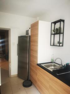 uma cozinha com um frigorífico de aço inoxidável e um lavatório em Studio - un lit en ville em Ath