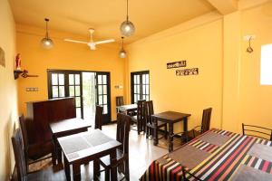 a restaurant with tables and chairs in a room at Edwin's Airport Garden in Negombo
