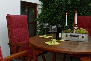 a wooden table with two glasses of wine and two candles at Ferienwohnung Peuker in Neukirchen bei Sulzbach-Rosenberg