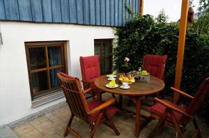 uma mesa de madeira e cadeiras num pátio em Ferienwohnung Peuker em Neukirchen bei Sulzbach-Rosenberg