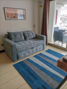 a living room with a blue couch and a rug at Depto. Full equipado in Iquique