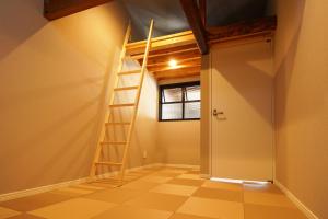 una habitación con una escalera junto a una puerta en Etcetera Guest House, en Niijimamura