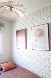 a room with two pictures and a ceiling fan at Charming Old North near Park by FeelHome in Tel Aviv