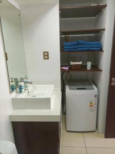 ein Badezimmer mit einem weißen Waschbecken und einem Spiegel in der Unterkunft Depto. Full equipado in Iquique