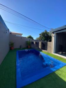 a blue swimming pool in the yard of a house at Ti kaz Tata du sud Sauvage in Saint-Joseph