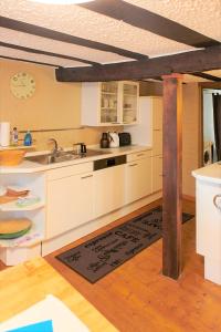 a kitchen with white cabinets and a wooden floor at Mählich Haus in Manderscheid