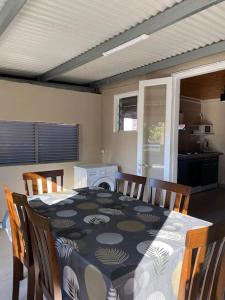 a dining room with a table and chairs and a kitchen at Ti kaz Tata du sud Sauvage in Saint-Joseph