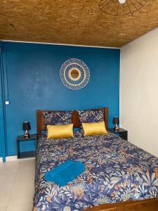 1 dormitorio con 1 cama con pared azul en Ti kaz Tata du sud Sauvage, en Saint-Joseph