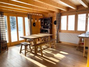 a dining room with a wooden table in a cabin at La Pourvoirie - 4 Vallées - Thyon-Les Collons, 10 personnes, pistes de ski à 200m, magnifique vue in Hérémence