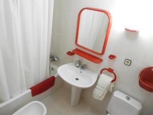 a bathroom with a sink and a toilet and a mirror at Aguadulce Primera Línea - A/C in Aguadulce +25 photos