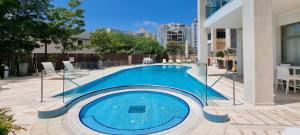 a large swimming pool in the middle of a building at Spacious Condo in New North by FeelHome in Tel Aviv