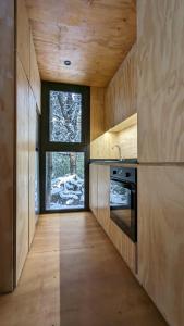 cocina con paredes de madera y ventana en El Bosque en San Carlos de Bariloche