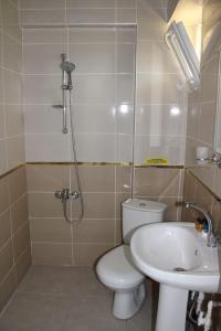 a bathroom with a shower and a toilet and a sink at GÖKÇEADA BATIHAN OTEL in Bademli