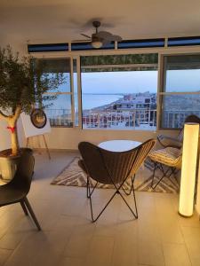 a living room with a table and chairs and a view of the ocean at Sunset 8F in Santa Pola