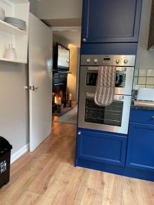 una cocina azul con horno en una habitación en The Gate-Lodge at Levally House en Monea