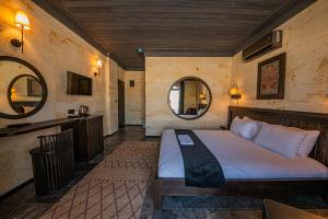 a bedroom with a bed and two mirrors at Perla Cappadocia in Göreme