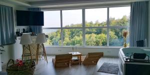 a living room with a tub and a large window at Wellness pod zvezdami, Maribor - PRIVATE in Maribor