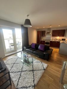a living room with a couch and a glass table at Quayside Apartments in Cardiff