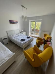塔特蘭斯卡魯門尼卡的住宿－Apartmán AkoDoma，一间卧室配有一张床和两张黄色椅子