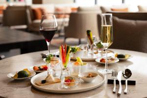 ANA InterContinental Appi Kogen Resort, an IHG Hotel في Hachimantai: طاولة مع أطباق من الطعام وكؤوس من النبيذ