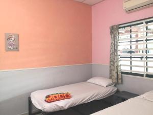 a room with two beds and a window at Hua Tang Homestay in Ipoh