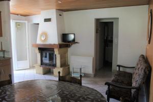 a living room with a table and a fireplace at La Pinède du Chéou, Piscine, Logement indépendant, Parking, Draps, Wifi fibre in Mimizan