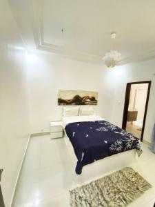 Habitación blanca con cama y alfombra en Superb apartment with jacuzzi no019 en Dakar