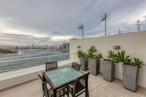 a patio with a table and chairs on a balcony at 49/3 Seafront Duplex Penthouse in Valletta in Valletta