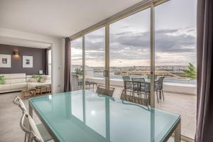 a living room with a glass table and a balcony at 49/3 Seafront Duplex Penthouse in Valletta in Valletta