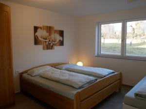 1 dormitorio con 2 camas y ventana en Ferienwohnung Haus Maria, en Wäschenbeuren