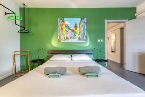 a bedroom with a large white bed with a green wall at 49/3 Seafront Duplex Penthouse in Valletta in Valletta