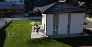 osoba siedząca przy stole z parasolką na trawniku w obiekcie Happy Nest w mieście Göstling an der Ybbs