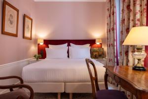 una camera d'albergo con letto, scrivania di Hotel Le Saint Gregoire a Parigi