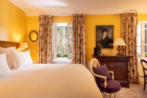 فندق لو سان غريغوار  في باريس: غرفة نوم بسرير ومكتب ونافذة