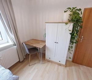 a small room with a table and a white cabinet at Gemütliches 3-Raum-Nest im 2.OG in Mittweida
