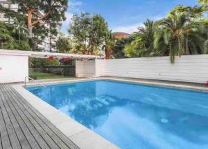 a large blue swimming pool with a white fence at Harbourside Style, 2 Bed, A/C, Pool -Elizabeth Bay in Sydney