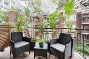 a patio with two chairs and a table on a balcony at Harbourside Style, 2 Bed, A/C, Pool -Elizabeth Bay in Sydney