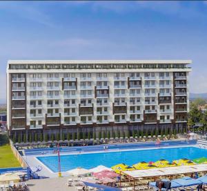 a hotel with a large swimming pool in front of a building at Lena_Lux in Jagodina