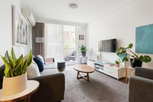 sala de estar con sofá y mesa en Harbourside Style, 2 Bed, A/C, Pool -Elizabeth Bay en Sídney