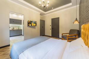 1 dormitorio con 1 cama blanca grande y 1 silla en Self Check-in Apartments en Kiev