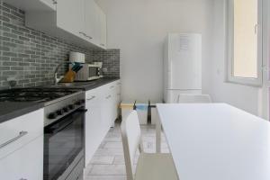 a kitchen with white cabinets and a white table at Wondrous Apartment Warszawska street in Krakow