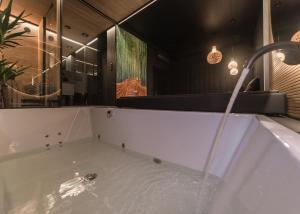a bathroom with a bath tub with a faucet at Eclipse Gold Room in Bielsko-Biała