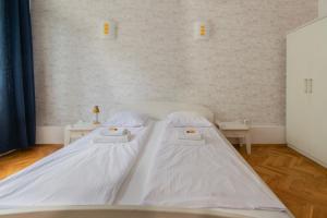 a white bed in a room with two tables at Wondrous Apartment Warszawska street in Krakow
