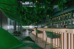 ミラノにあるHyatt Centric Milan Centraleの緑の椅子とバーのあるレストラン