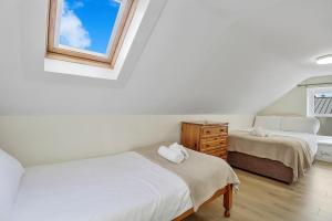 ein Schlafzimmer mit zwei Betten und einem Fenster in der Unterkunft The Wee House in Muff